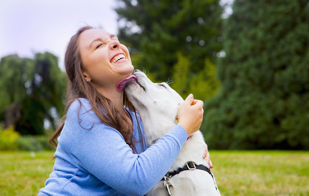 Woman being licked by playful dog