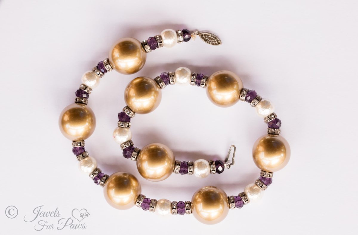 large gold pearl beads with small cultured pearls, purple swarovski crystals with channel set swarovski rhinestone spacers on white background