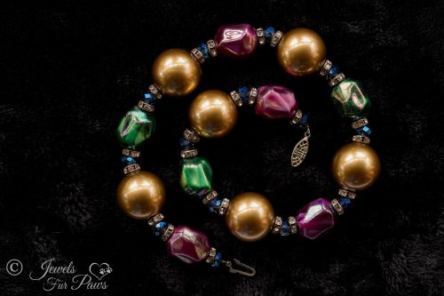 large gold pearl beads with iridescent green and pink bauble beads clear swarovski crystal spacers channel set swarovski crystal rhinestone spacers on black background