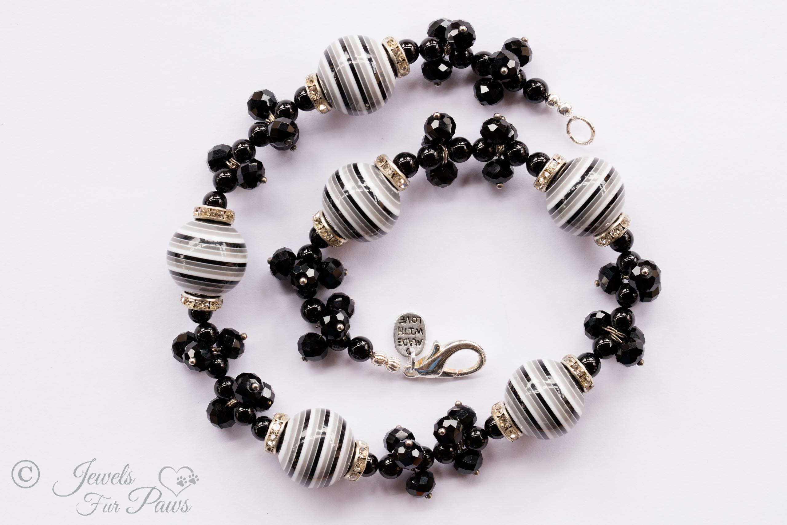 Six large black and white striped beads with black swarovski crystal clusters on white background