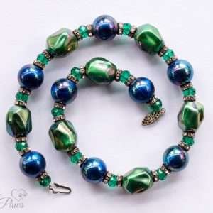 iridescent green bauble beads with iridescent blue pearl beads strung with green swarovski crystals and channel set rhinestone rondells on white background