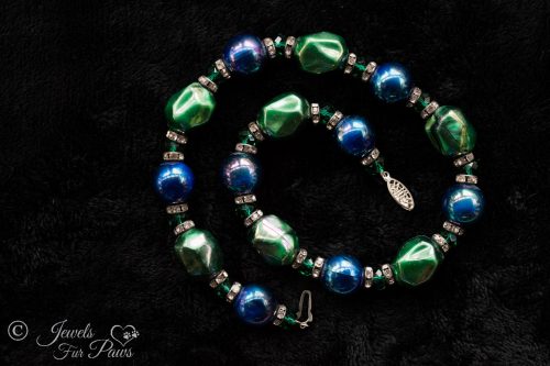 iridescent green bauble beads with iridescent blue pearl beads strung with green swarovski crystals and channel set rhinestone rondells on black background