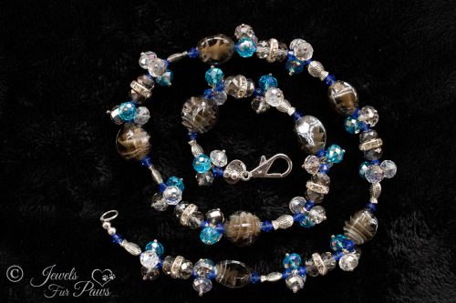 light brown tigers eye oval glass beads strung with different blue faceted Czech crystals and silver fish pet jewelry dog jewelry on white background