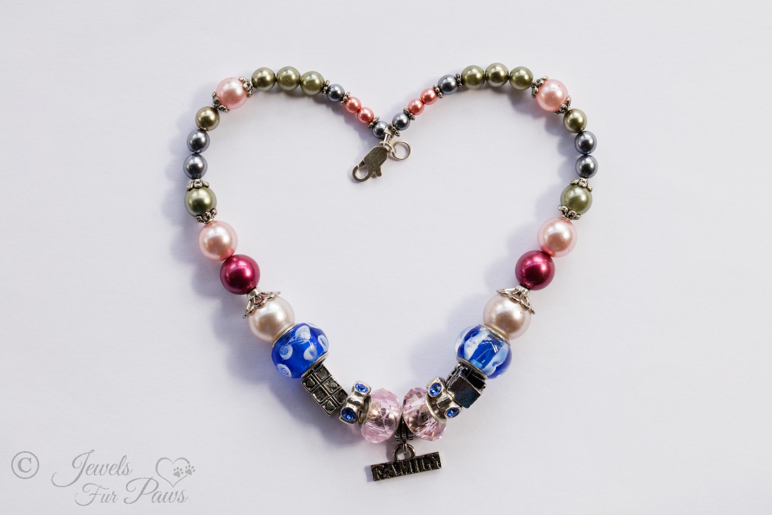 large pink faceted czech crystals with rhinstone rhondells, blue murano glass beads, pink pearls, gray pearls on white background