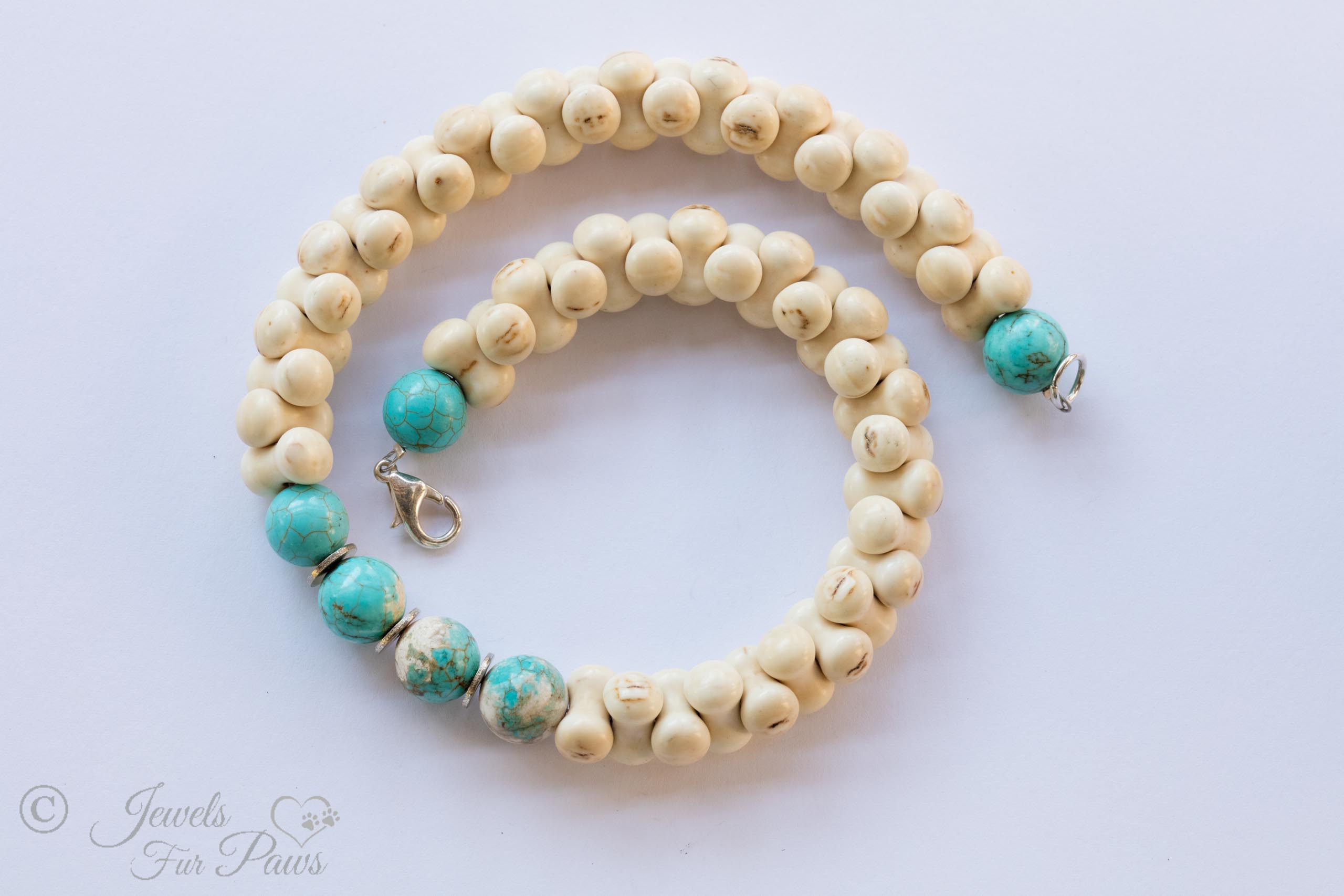 interlocking bone shaped beads surround four turquoise beads with turquoise end beads on white background
