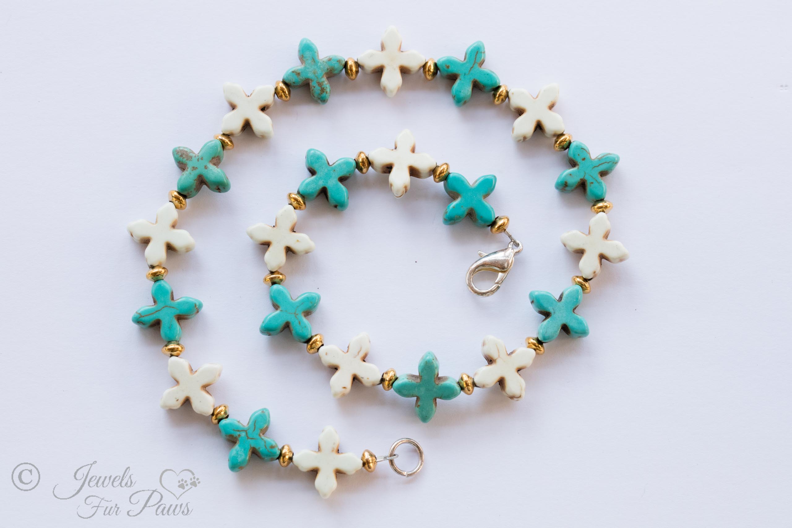 dog cat pet necklaces jewelry eleven pale blue turquoise crosses with eleven white howlite crosses and gold spacers on a white background