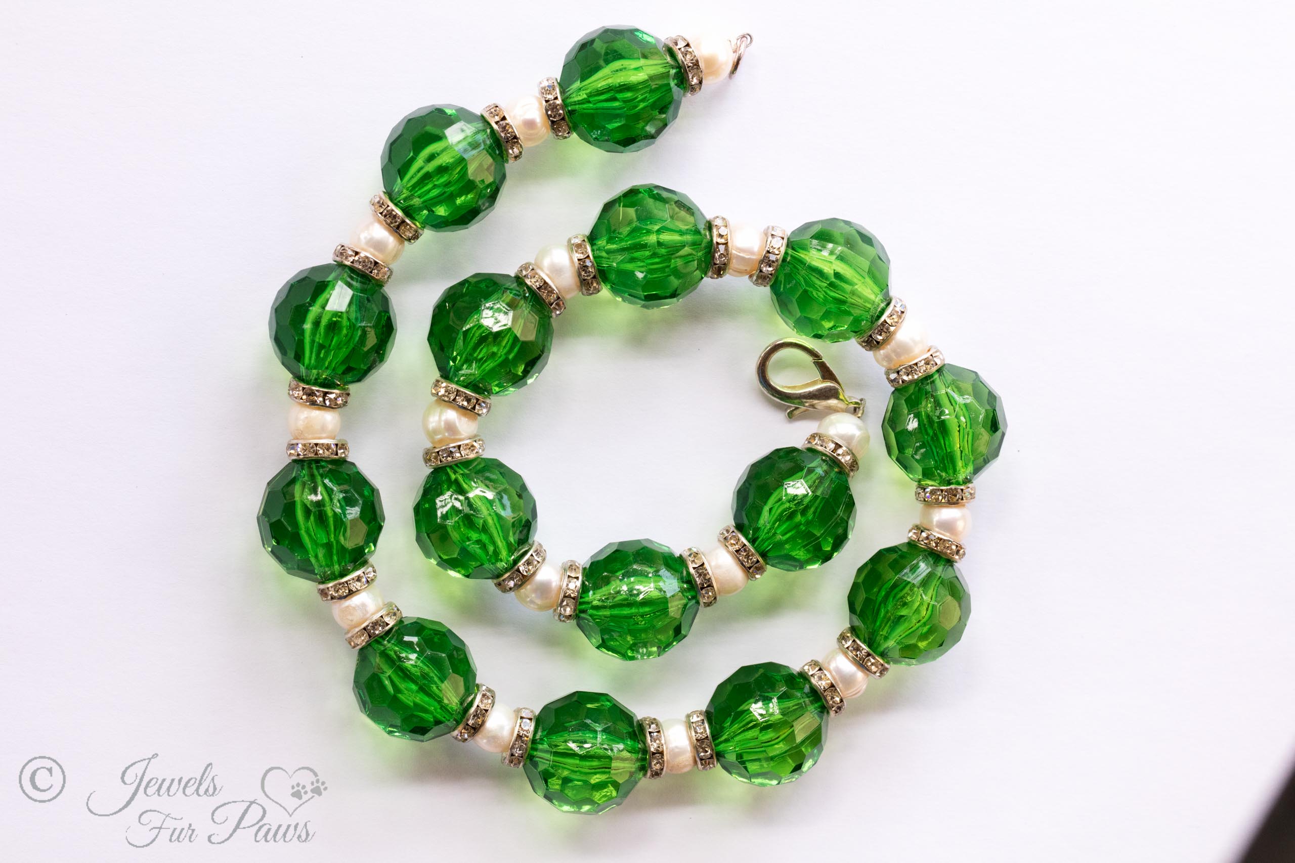 round green acrylic faceted beads strung with cultured pearls and channel set Swarovski crystal spacers on white background