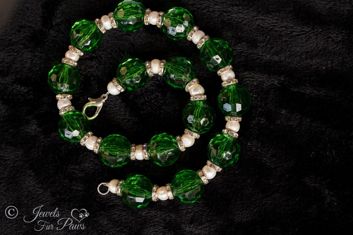 round green acrylic faceted beads strung with cultured pearls and channel set Swarovski crystal spacers on black background