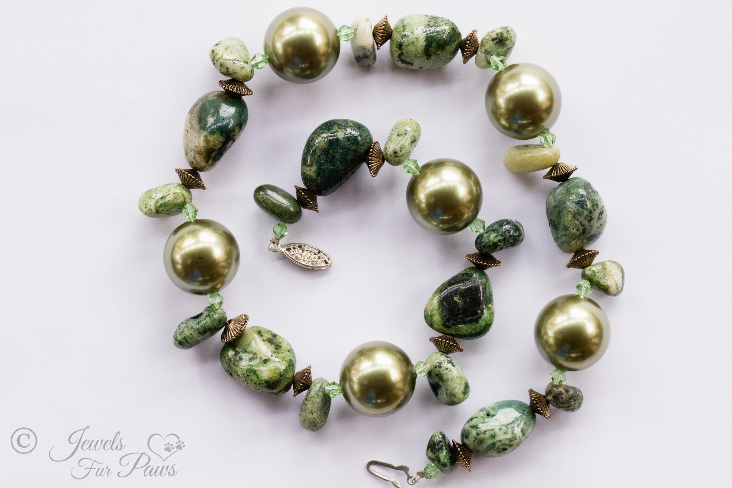 large gold pearl beads with irregular shaped jade nugget beads with gold spacers on white background