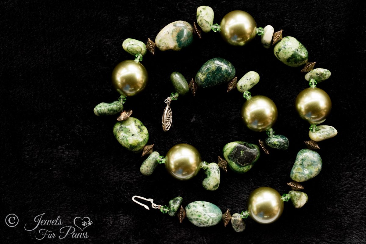 large gold pearl beads with irregular shaped jade nugget beads with gold spacers on black background