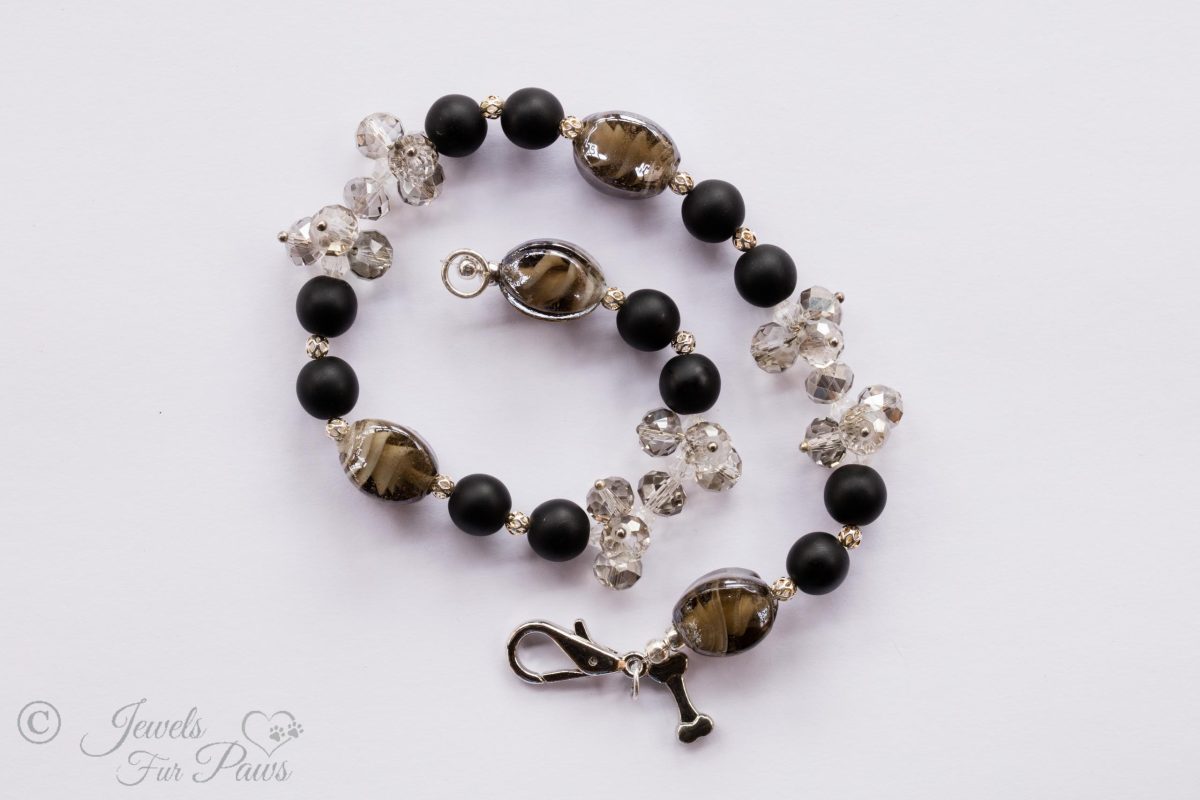 natural black lava beads with clear swarovski crystal clusters and black lampwork glass beads on a white background