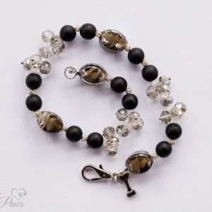 natural black lava beads with clear swarovski crystal clusters and black lampwork glass beads on a white background