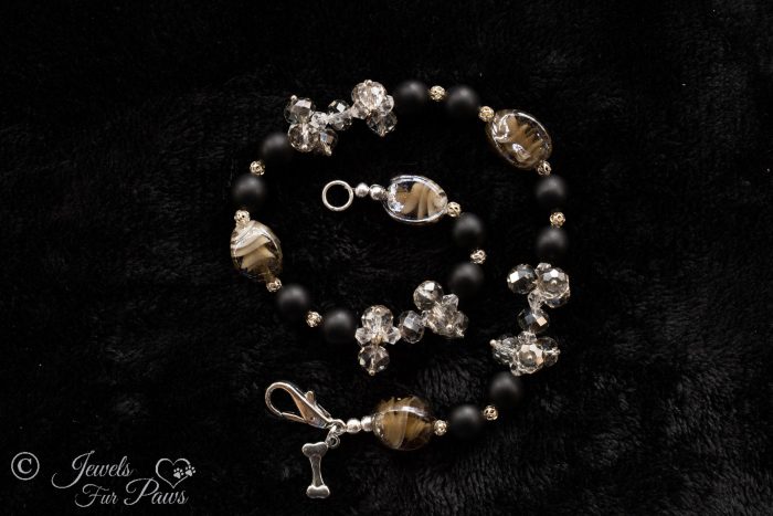 natural black lava beads with clear swarovski crystal clusters and black lampwork glass beads on a white background
