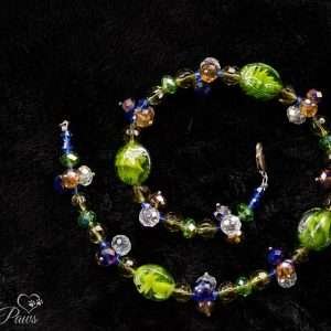 four green lampwork beads with multi-colored swarovski crystals spacer clusters on black background
