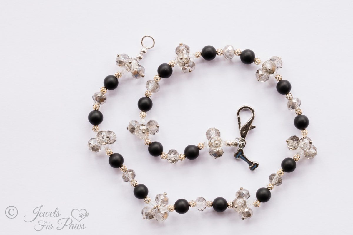 natural lava black beads strung with clear Swarovski crystals and crystal clusters on white background
