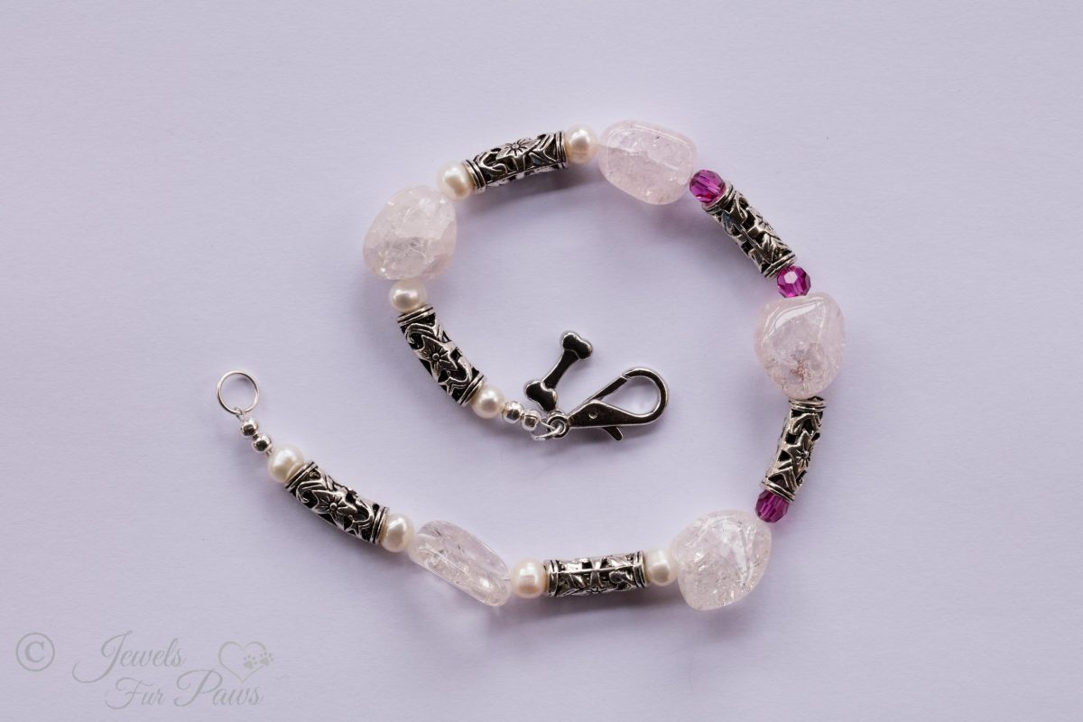five chunky rose quartz crystals, silver barrel rondells, three ruby red czech crystals on white background