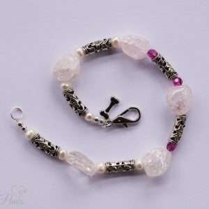 five chunky rose quartz crystals, silver barrel rondells, three ruby red czech crystals on white background