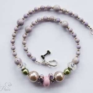 pale pink round bead wtih purple swarovski crystal spacers, two silver pearl beads, two olive green pearl beads, with lavender round beads and silver rondell spacers on a white background