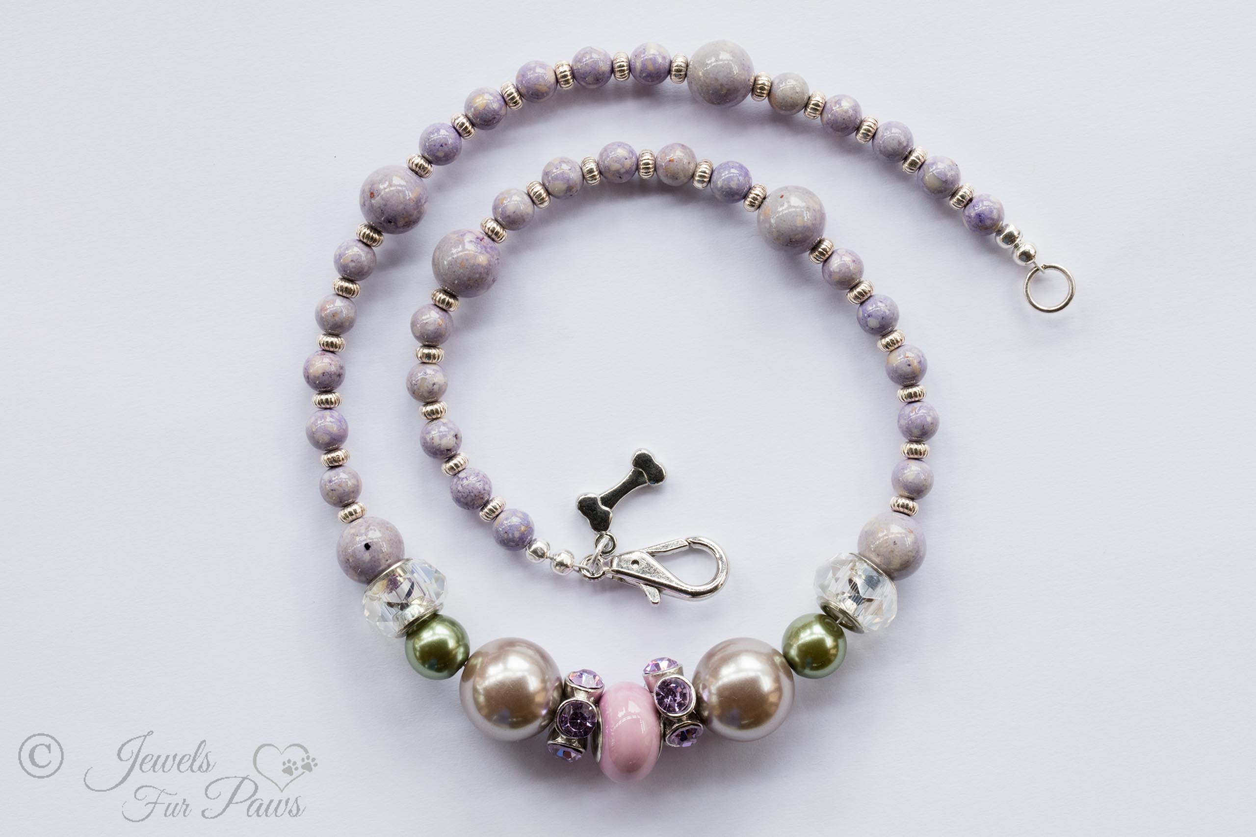 pale pink round bead wtih purple swarovski crystal spacers, two silver pearl beads, two olive green pearl beads, with lavender round beads and silver rondell spacers on a white background