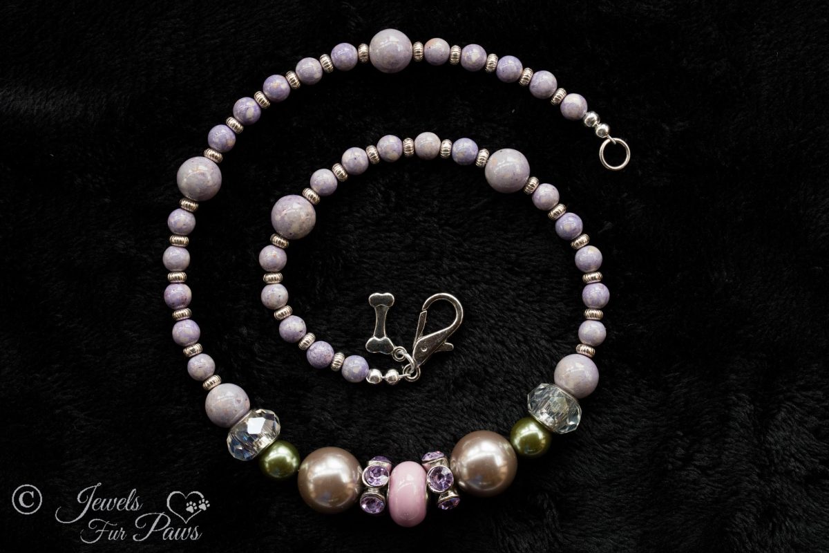 pale pink round bead wtih purple swarovski crystal spacers, two silver pearl beads, two olive green pearl beads, with lavender round beads and silver rondell spacers on a black background
