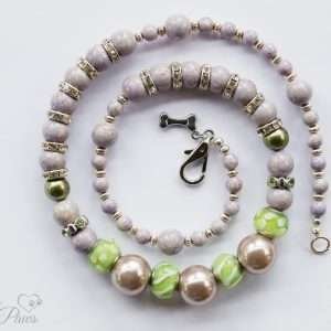 three large iridescent lavender silver pearl beads with green glass beads with swarovski channel set spacers and lavender beads on white background