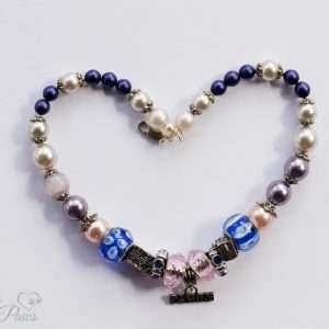 two large faceted pink crystals surround a hanging family charm with pearls, murano crystals on white background