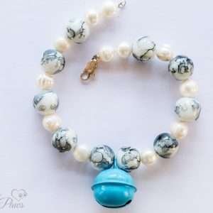 the bell in robin blue pet necklace with pearls and marbelized white and blue beads on white background