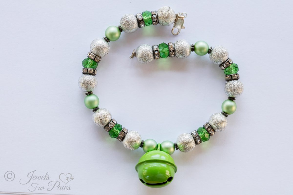 the bell in green with hammered silver beads and green czech crystals with spacers on white background