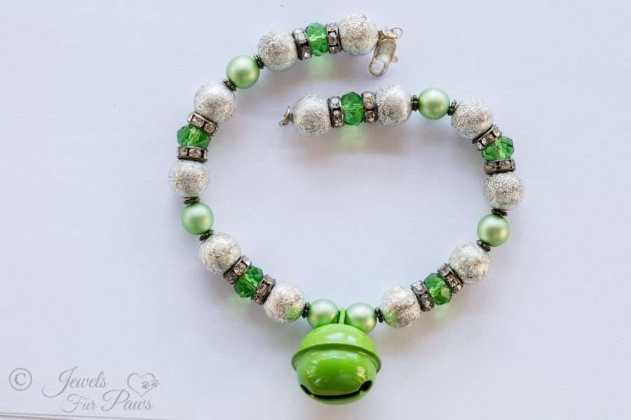 the bell in green with hammered silver beads and green czech crystals with spacers on white background