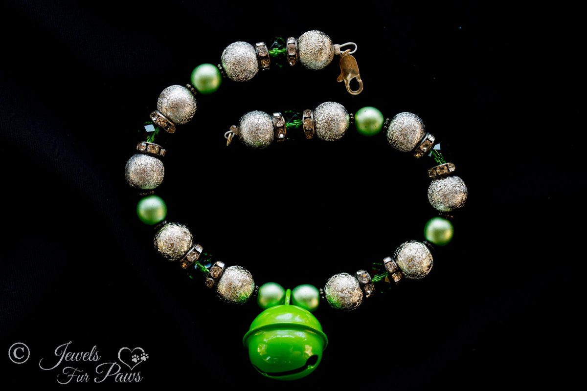 the bell in green with hammered silver beads and green czech crystals with spacers on black background
