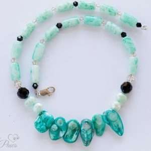 aqua marbleized beads interspersed with black Swarovski crystals complementing five aqua Burmese pearls on a white background