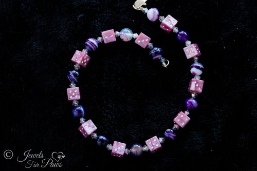 lucky purple dice with blue and purple marble beads and crystal spacers on black background