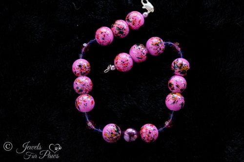 Hot Pink Speckled beads with purple swarovski crystal spacers and purple pearl on black background