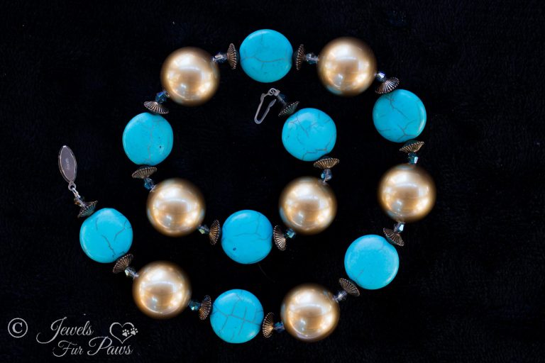 large gold pearl beads with silver rondell spacers and flat turquoise disc beads on black background