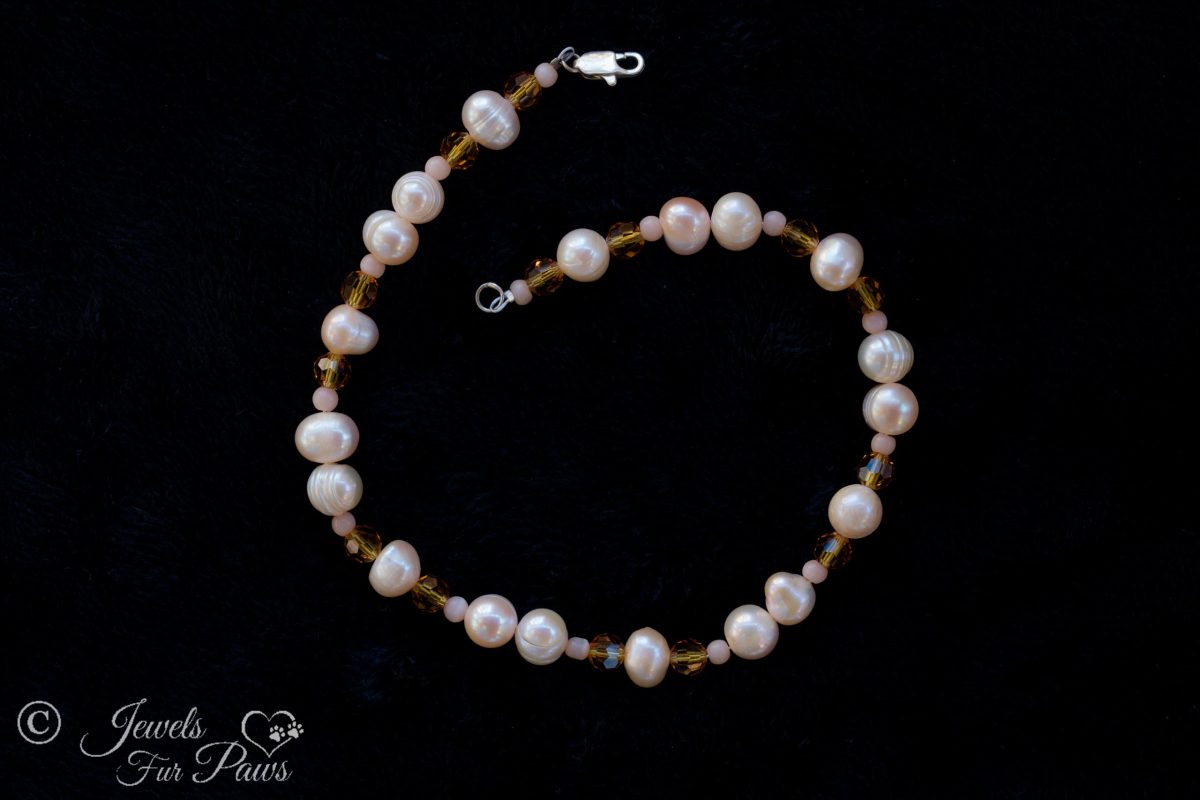 cultured pearls strung with amber czech crystals on black background