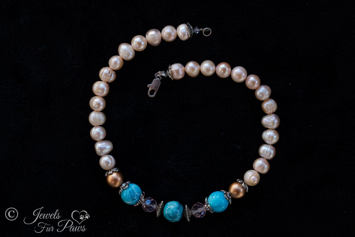 antique vintage Japanese cultured pearls complementing three turquoise marbleized bads with two copper pearls and pale pink crystals on black background
