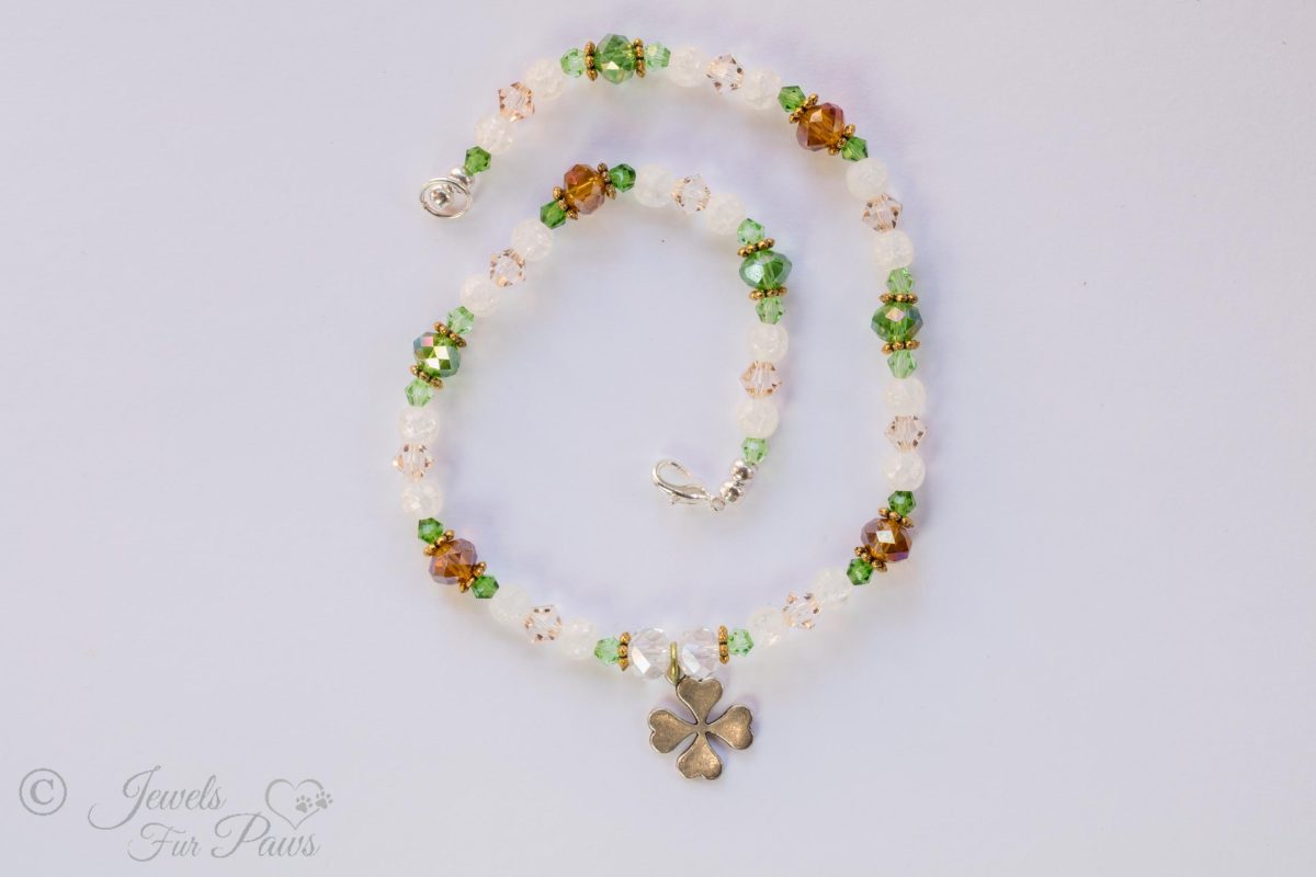 dog cat pet necklace green, white and amber beads with silver hanging lucky shamrock four leaf clover charm on white background