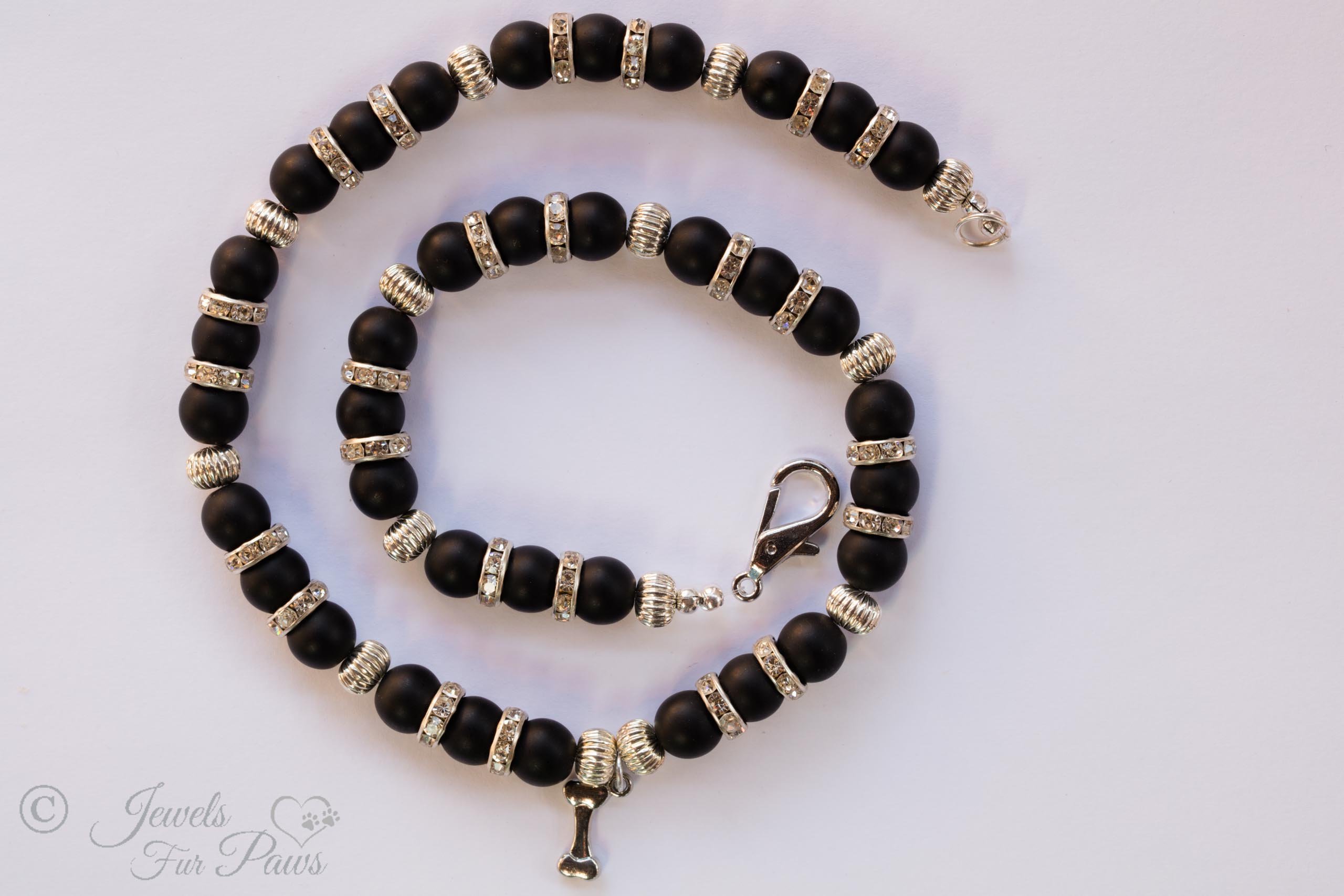 cat dog pet necklace natural black lava round beads with swarovski channel set spacers and silver rondels with hanging bone charm on white background