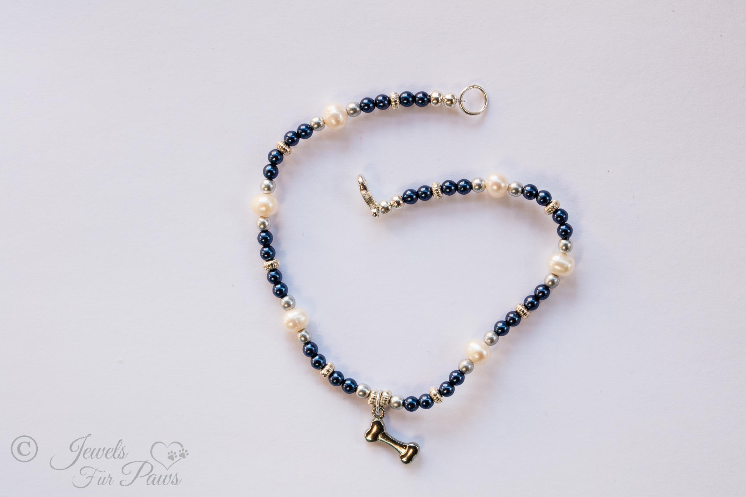 cat dog pet necklace for small dogs or cats navy blue and silver beads with cultured pearls and hanging silver dog bone charm on white background