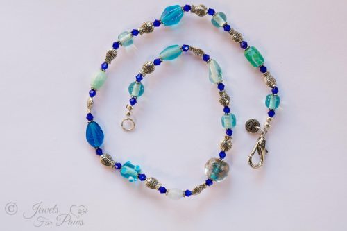 cat dog pet necklace with large blue crystals and large marbleized bead with silver fish spacers on white background